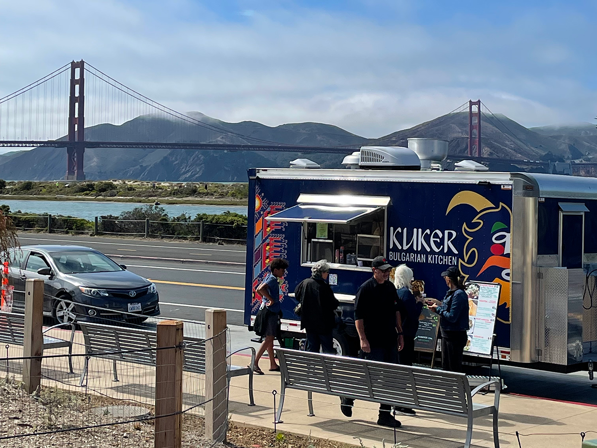 Food truck parked outside surrounded by patrons.